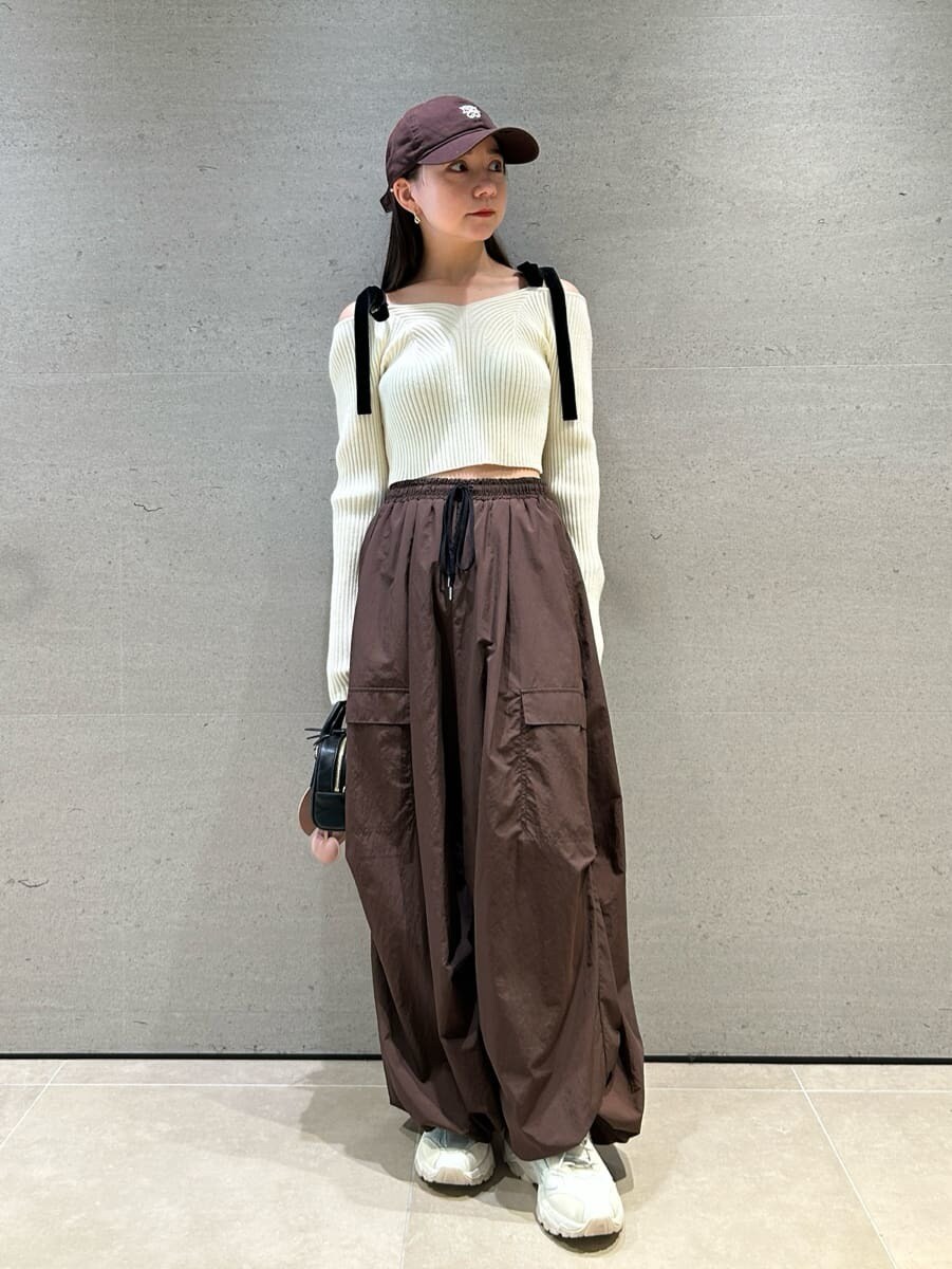 ホワイト系のニット/セーター、ブラウン系のその他パンツ、ブラック系のボストンバッグを着用したレディースの夏コーディネートの4枚目の写真