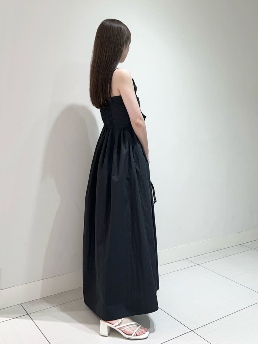 ブラック系のかごバッグ、ホワイト系のサンダル、ブラック系のワンピースを着用したレディースの夏コーディネートの3枚目の写真