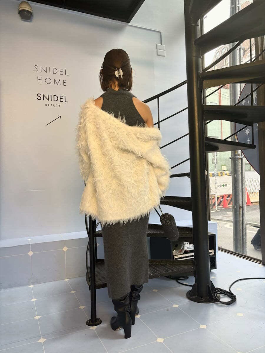 グレー系のワンピース、ホワイト系のカーディガン/ボレロを着用したレディースの冬コーディネートの4枚目の写真