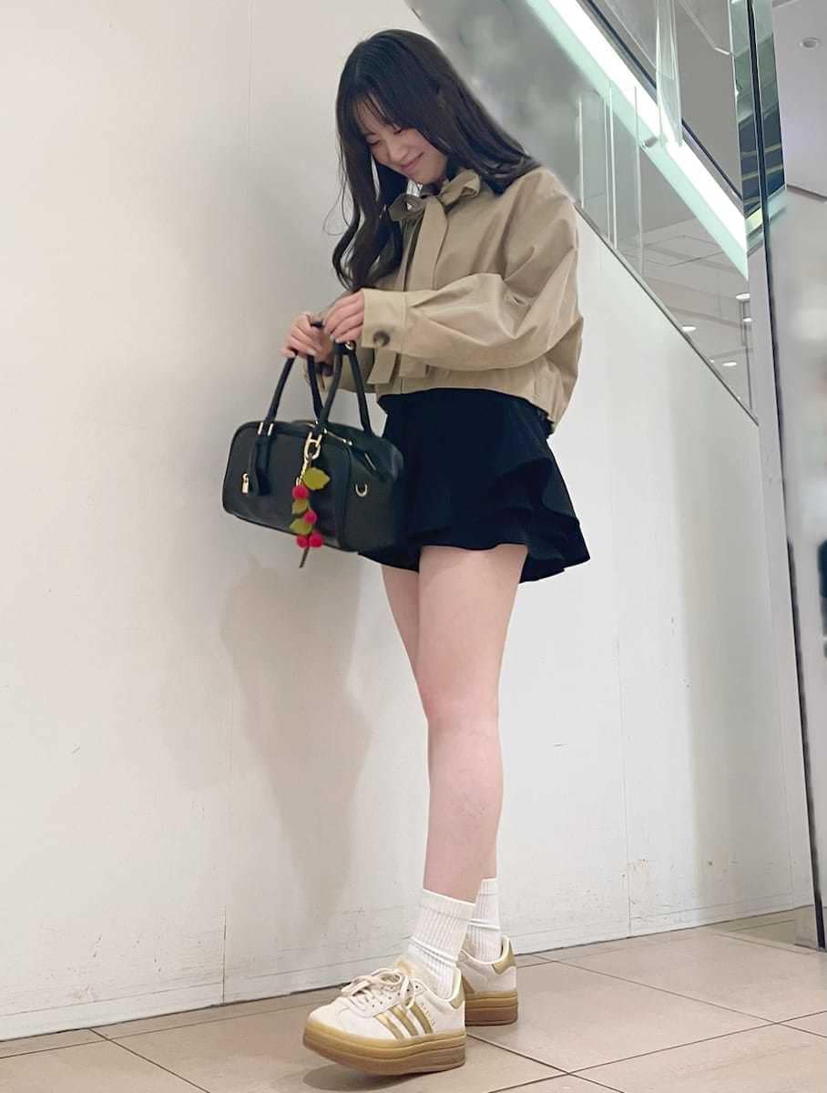 ベージュ系のブルゾン、ブラック系のボストンバッグ、ゴールド系のスニーカーを着用したレディースの冬コーディネートの2枚目の写真