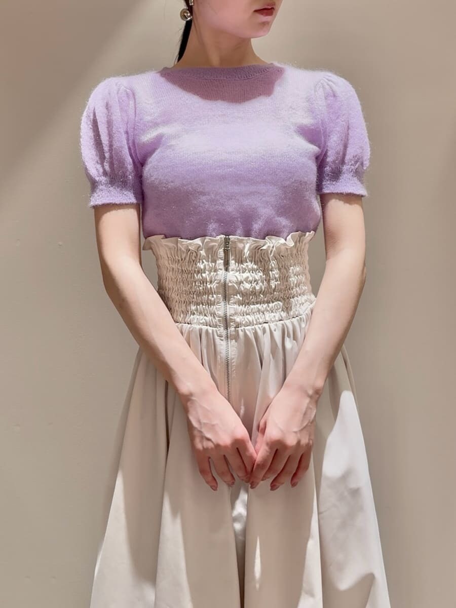 パープル系のニット/セーター、ホワイト系のスカート、ベージュ系のショルダーバッグを着用したレディースの夏コーディネートの4枚目の写真