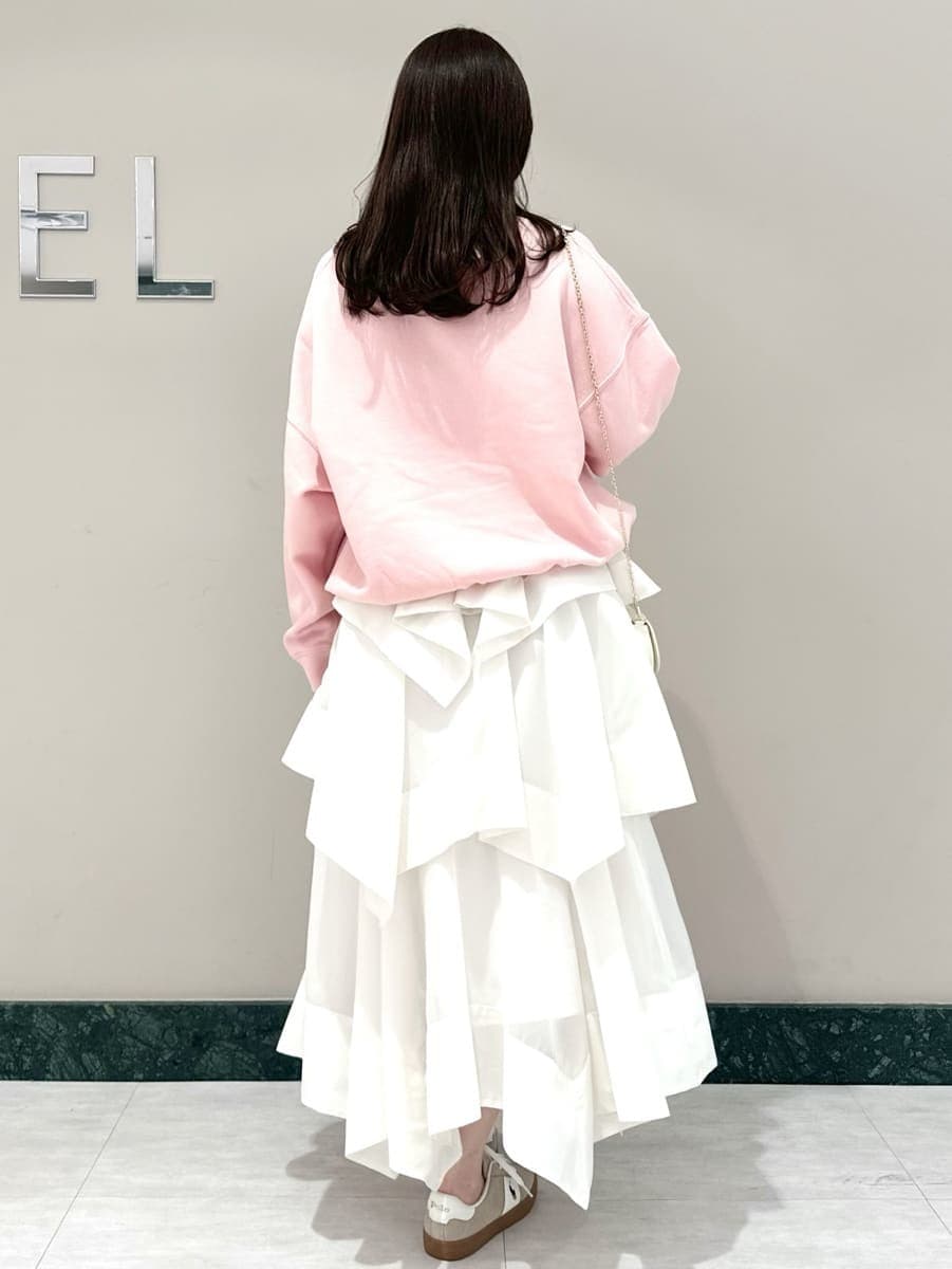 ホワイト系のスカート、ピンク系のスウェット、ホワイト系のショルダーバッグを着用したレディースの春コーディネートの5枚目の写真