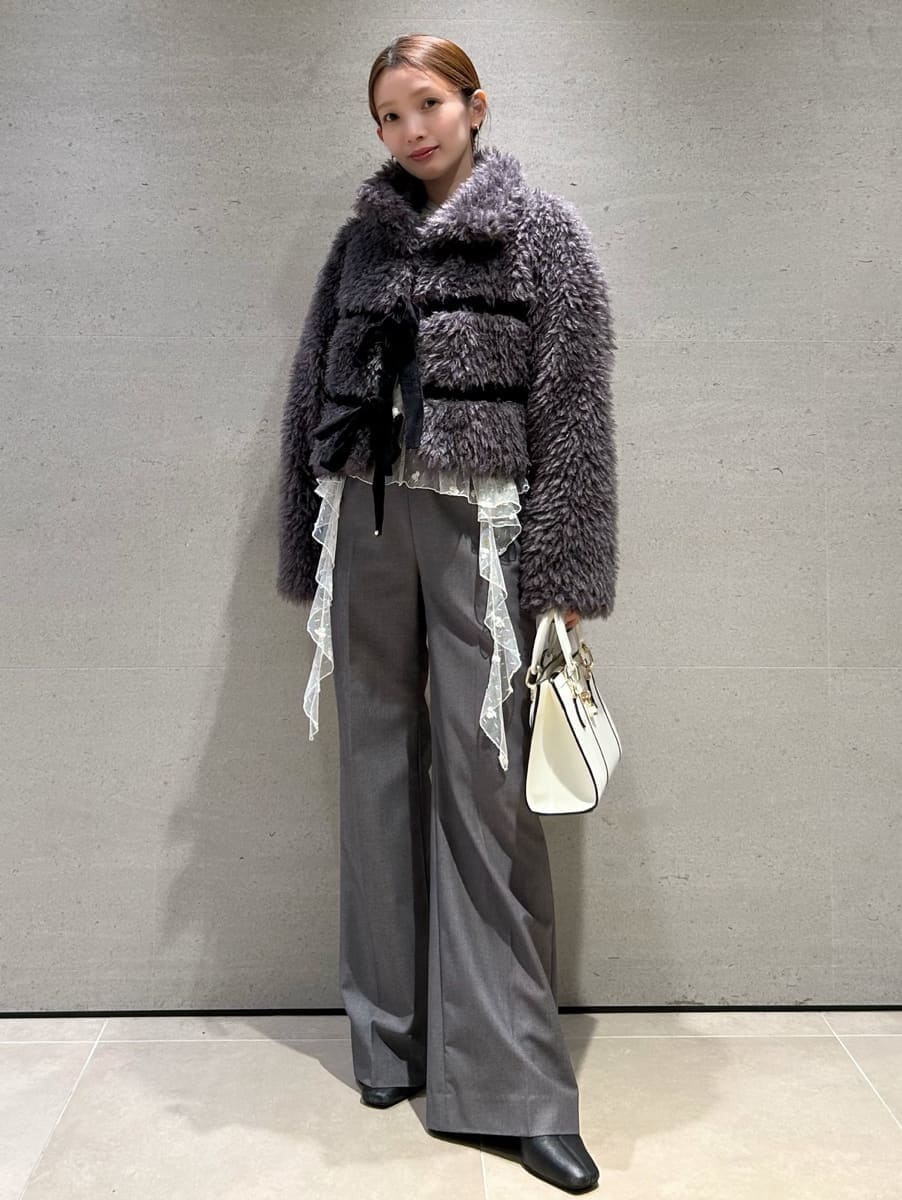 グレー系のムートンコート、グレー系のスラックス、その他のシャツ/ブラウスを着用したレディースの秋コーディネートの4枚目の写真
