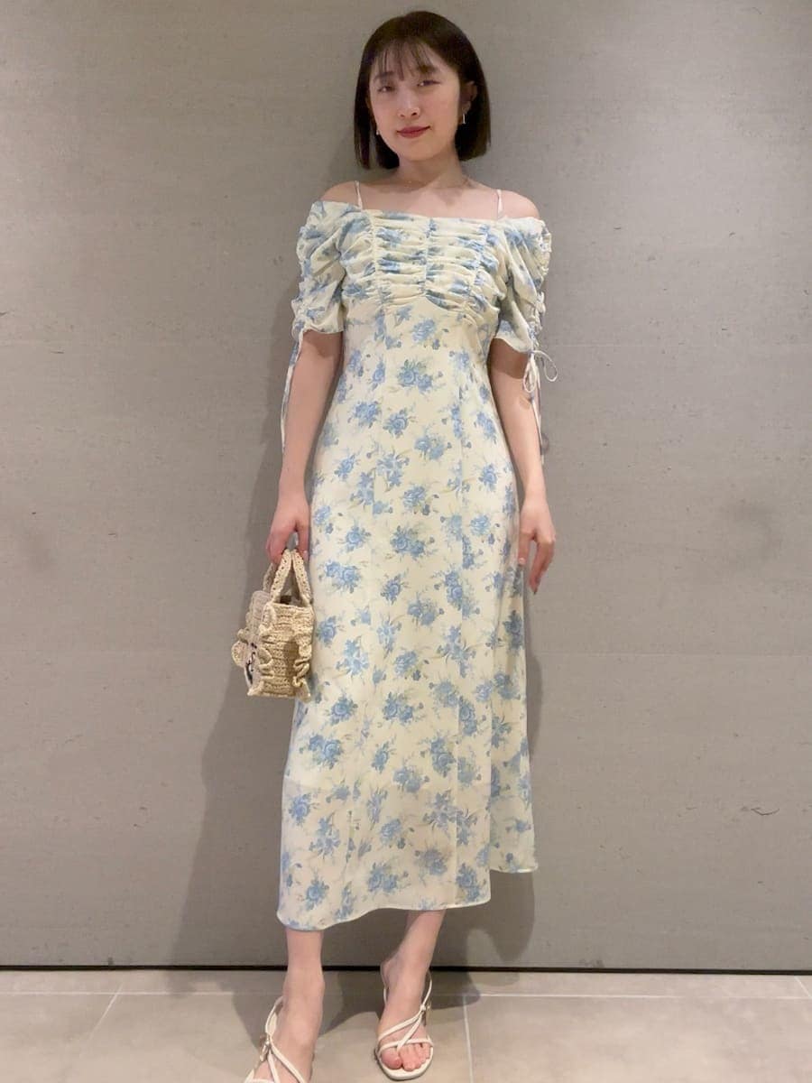 ベージュ系のショルダーバッグ、イエロー系のワンピースを着用したレディースの春コーディネートの2枚目の写真