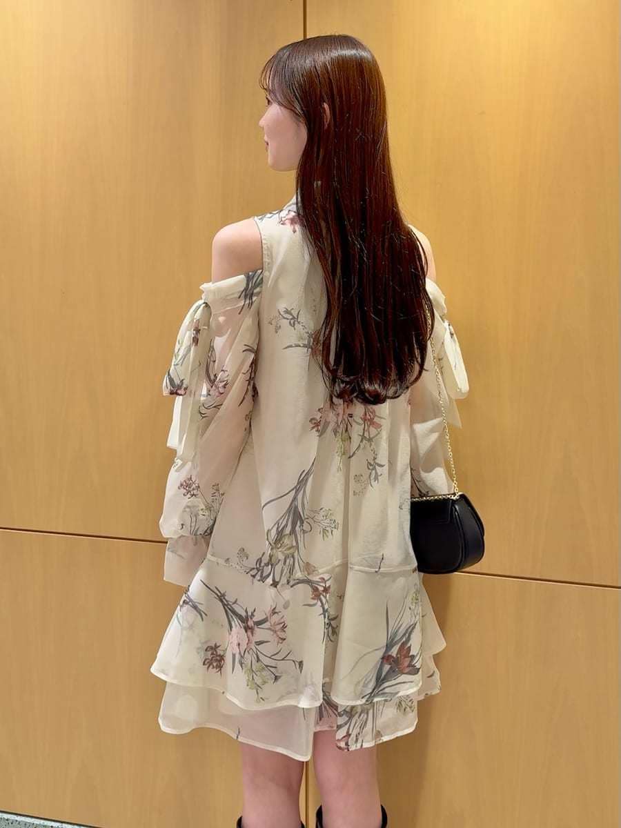 イエロー系のワンピース、ブラック系のショルダーバッグ、シルバー系のピアス（両耳用）を着用したレディースの冬コーディネートの7枚目の写真