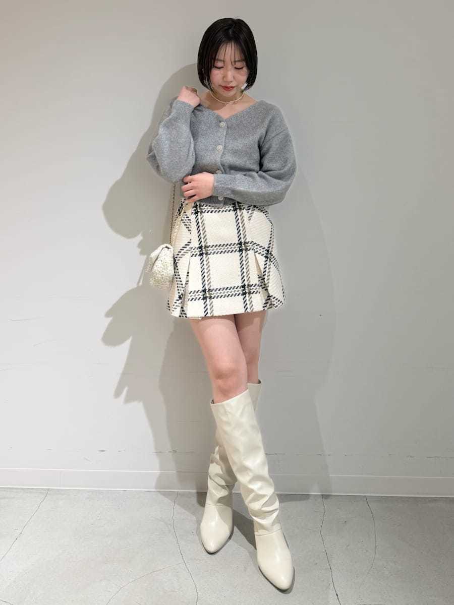 ホワイト系のスカート、グレー系のカーディガン/ボレロ、ゴールド系のキーケース/キーアクセサリーを着用したレディースの冬コーディネートの7枚目の写真