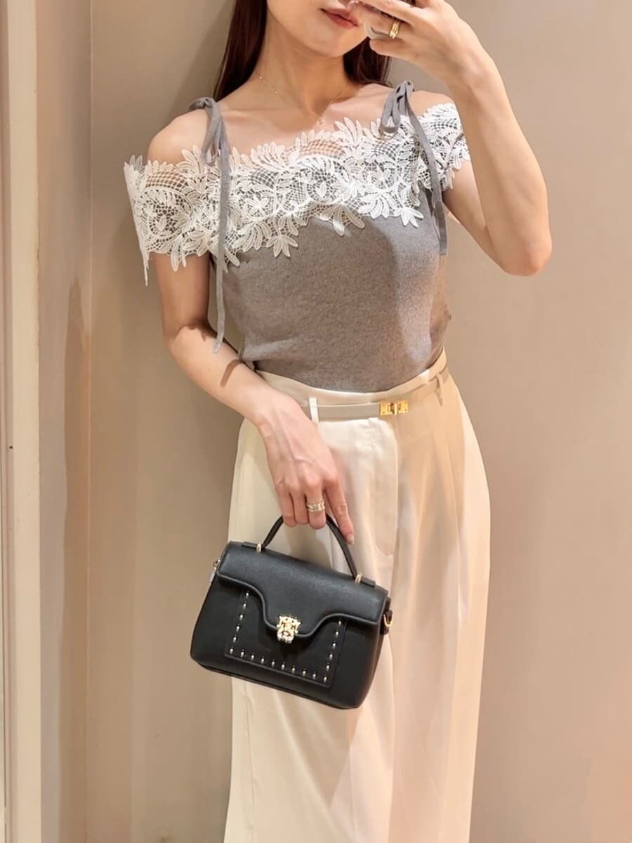 グレー系のニット/セーター、ホワイト系のその他パンツ、ブラック系のショルダーバッグを着用したレディースの夏コーディネートの6枚目の写真