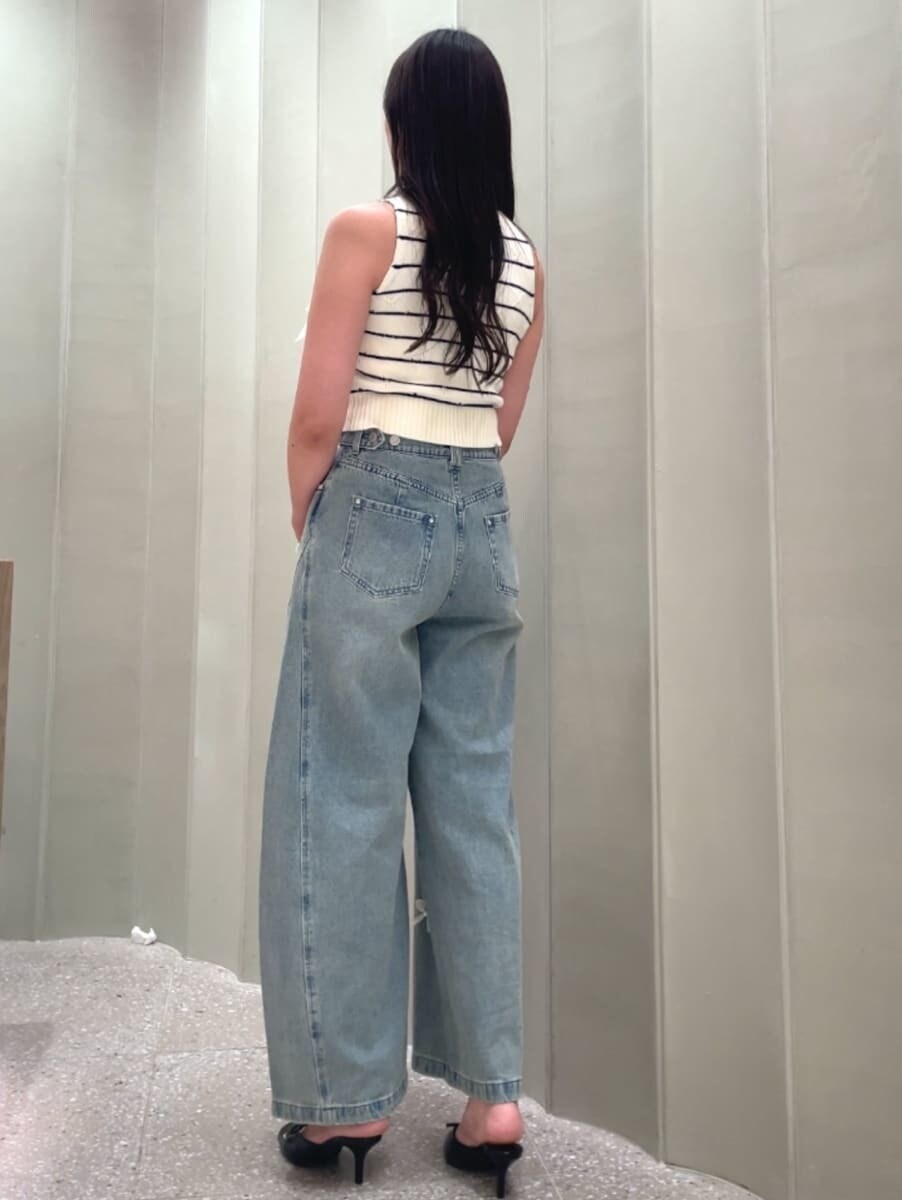 ブラウン系のハンドバッグ、ブルー系のその他パンツ、その他のニット/セーターを着用したレディースの夏コーディネートの5枚目の写真