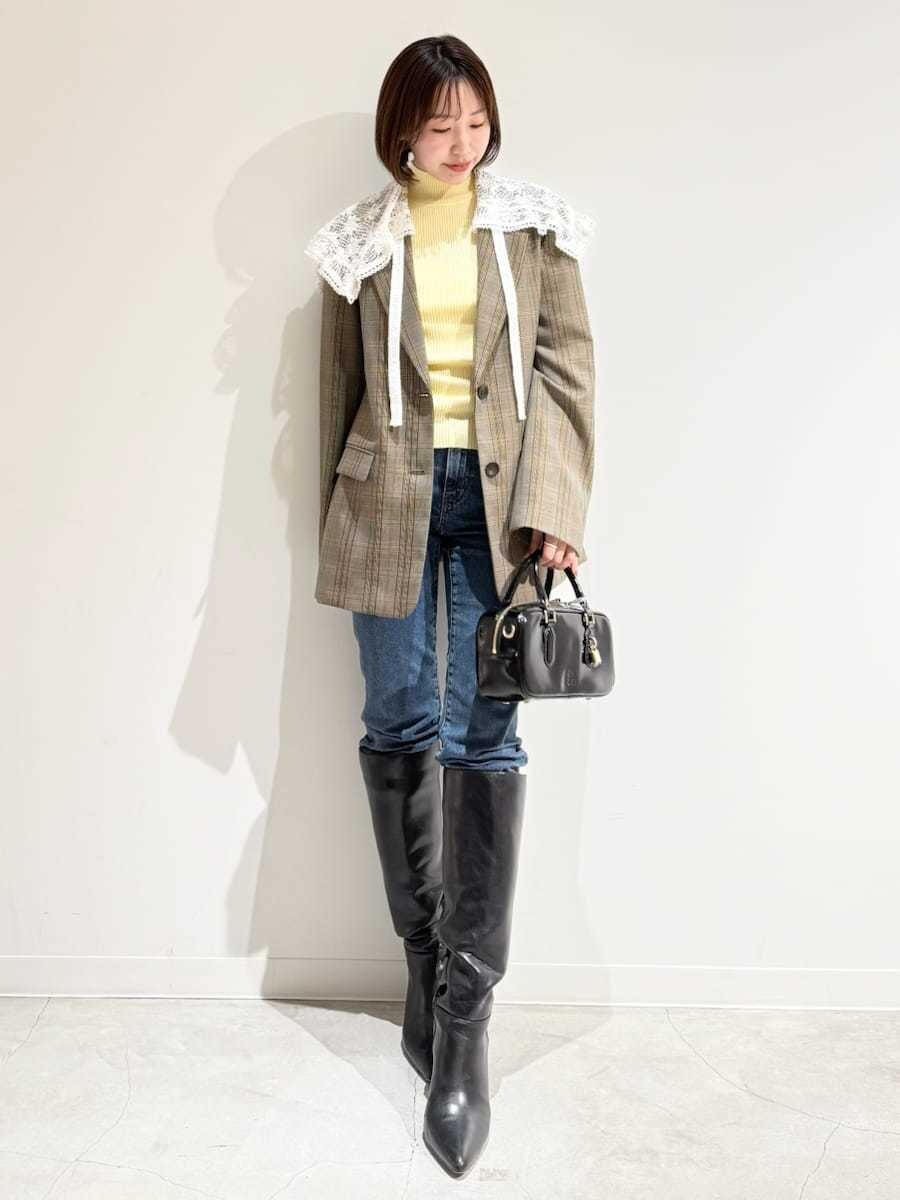 イエロー系のニット/セーター、その他のテーラードジャケット、ブルー系のデニムパンツを着用したレディースの秋コーディネートの4枚目の写真