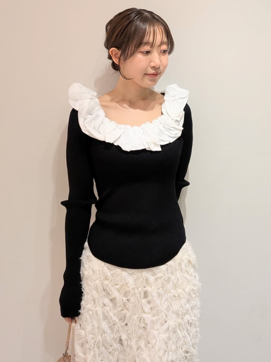 ブラック系のブーツ、ホワイト系のスカート、その他のニット/セーターを着用したレディースの冬コーディネートの4枚目の写真