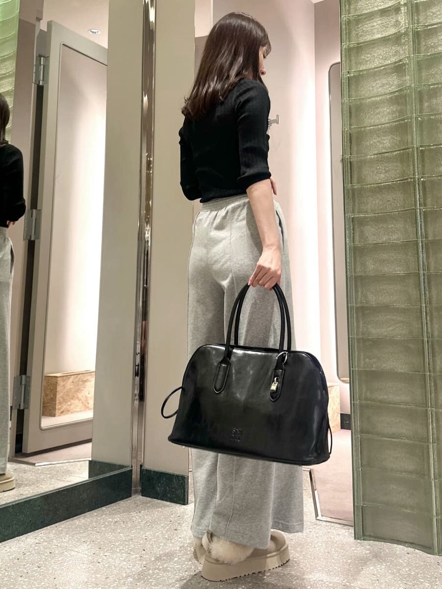 ブラック系のニット/セーター、グレー系のその他パンツ、ブラック系のハンドバッグを着用したレディースの秋コーディネートの4枚目の写真