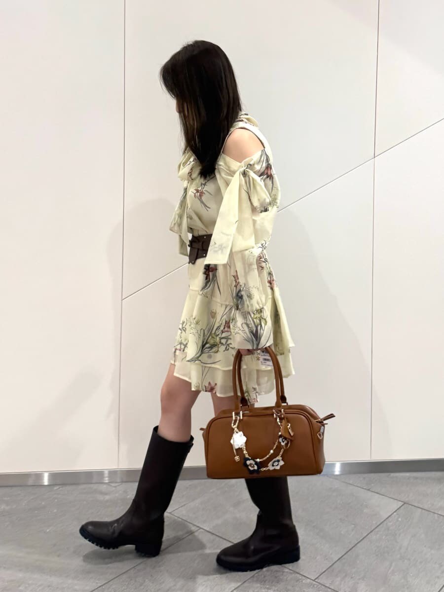 ブルー系のワンピース、イエロー系のボストンバッグ、ブラウン系のベルトを着用したレディースの冬コーディネートの5枚目の写真