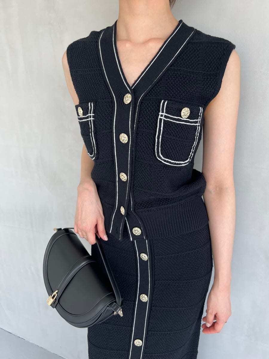 ブルー系のニット/セーター、ブルー系のスカート、ブラック系のハンドバッグを着用したレディースの夏コーディネートの5枚目の写真