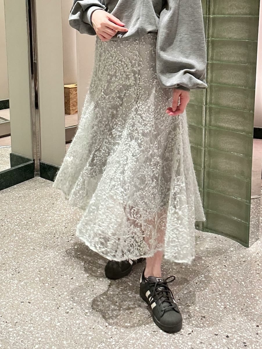 グレー系のTシャツ/カットソー、グリーン系のスカート、グレー系のスニーカーを着用したレディースの秋コーディネートの3枚目の写真