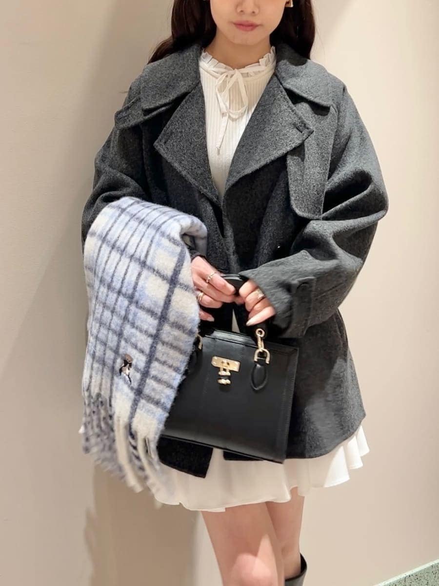 ホワイト系のワンピース、ブラック系のハンドバッグ、ブルー系のマフラーを着用したレディースの冬コーディネートの4枚目の写真