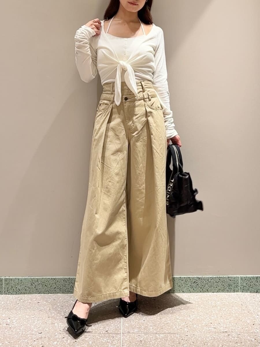 ホワイト系のTシャツ/カットソー、ベージュ系のデニムパンツ、ブラック系のハンドバッグを着用したレディースの秋コーディネートの2枚目の写真