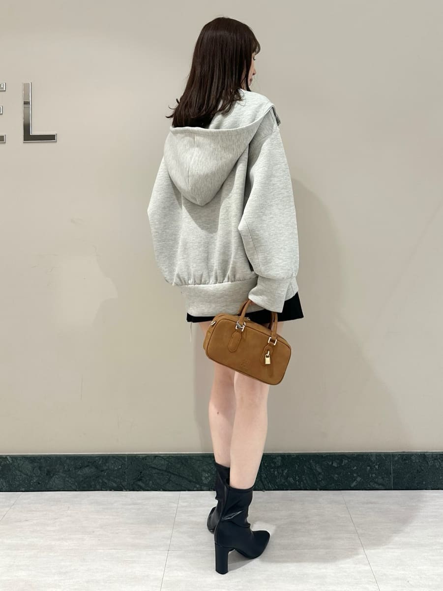 グレー系のパーカー、ブラック系のスカート、ブラック系のブーツを着用したレディースの夏コーディネートの4枚目の写真