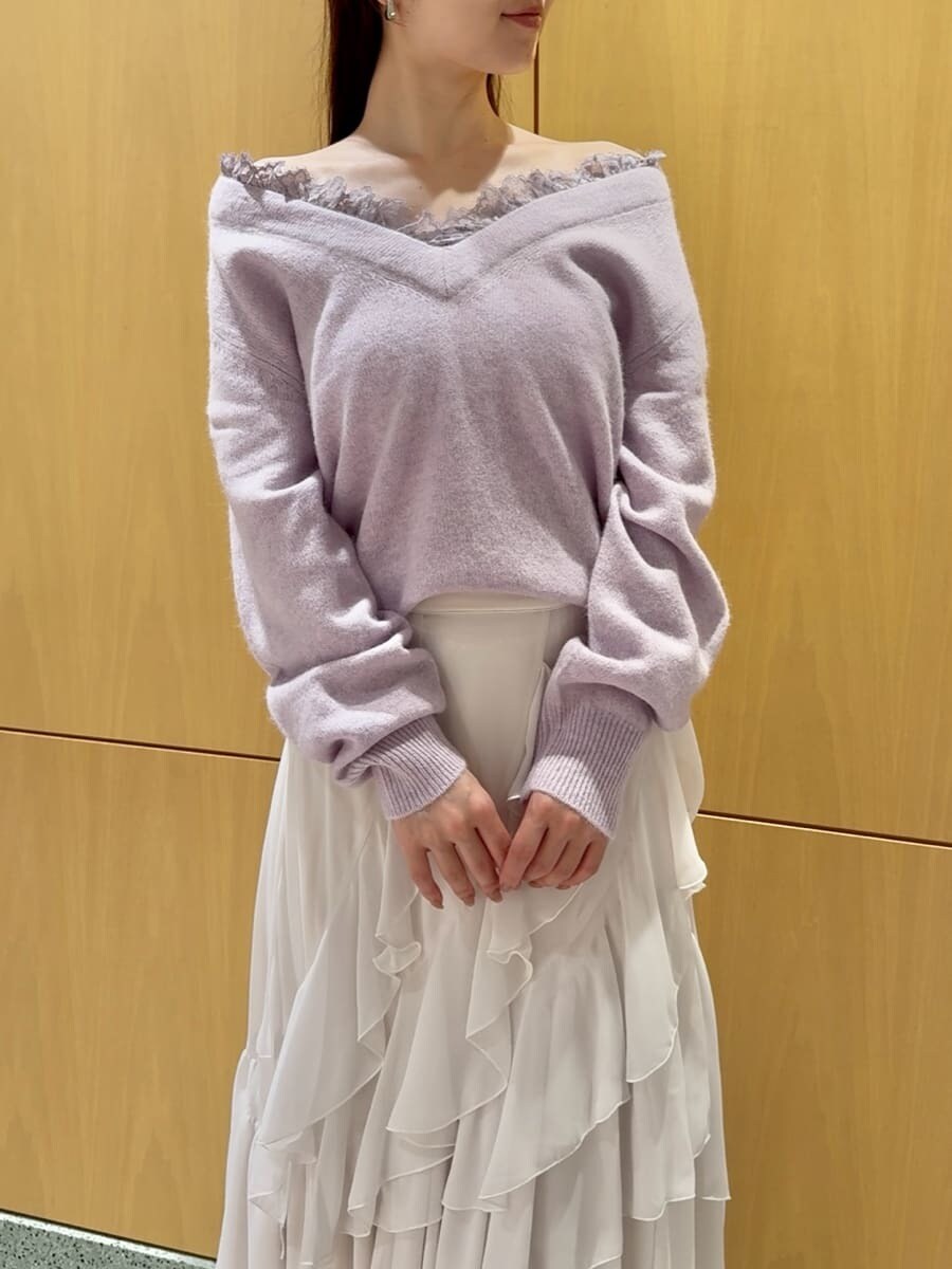 パープル系のニット/セーター、ホワイト系のスカート、ブラック系のブーツを着用したレディースの秋コーディネートの4枚目の写真