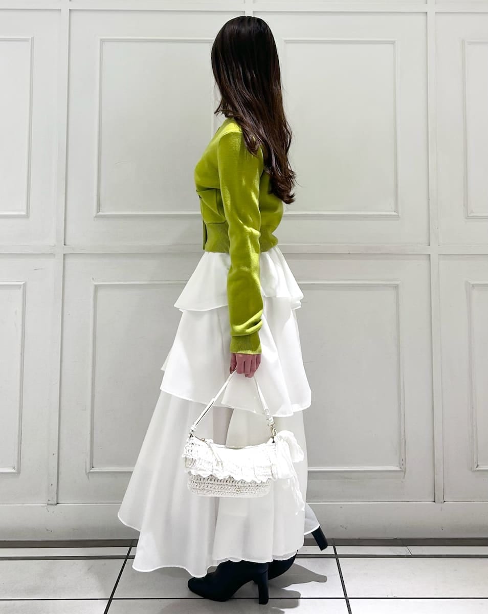 ブラック系のブーツ、イエロー系のワンピース、その他のイヤリングを着用したレディースの冬コーディネートの2枚目の写真