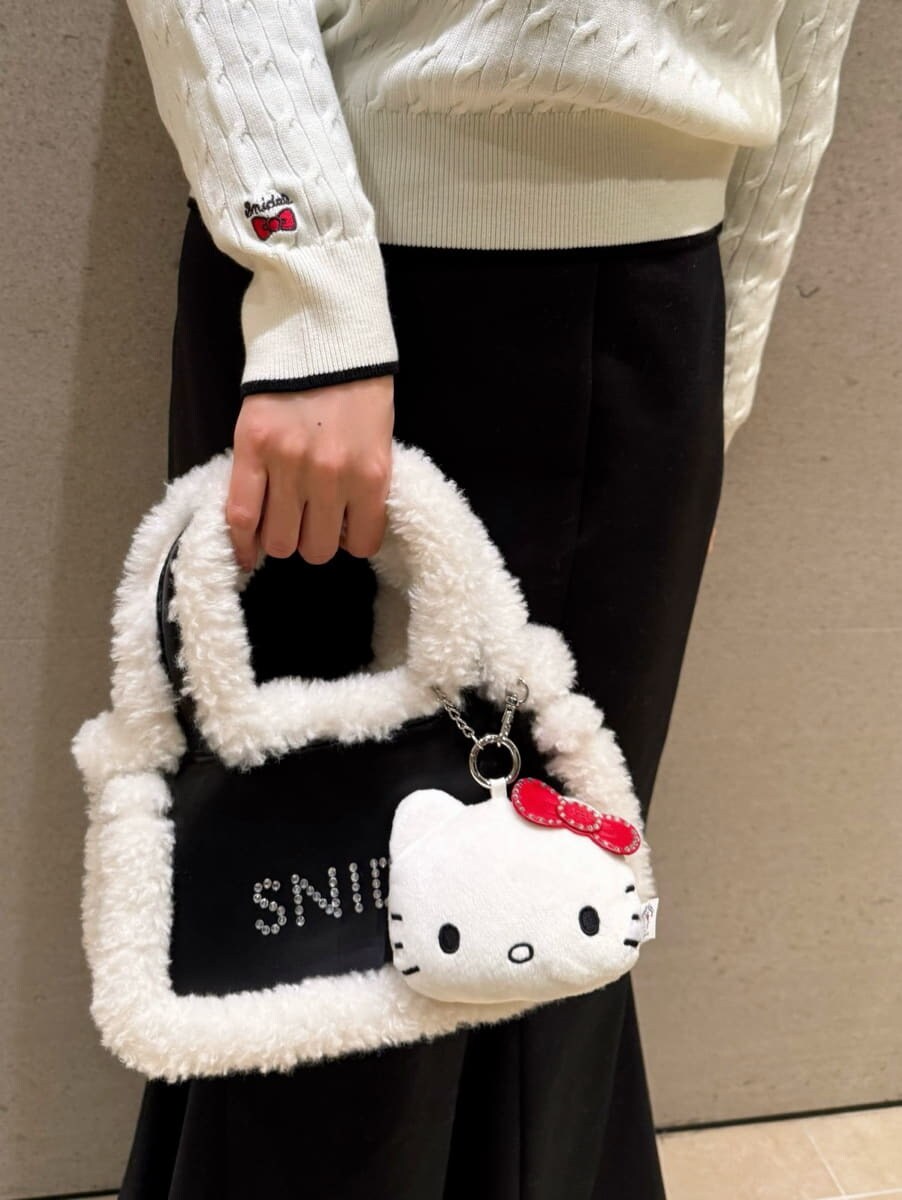 ホワイト系のニット/セーター、ブラック系のハンドバッグ、ブルー系のシャツ/ブラウスを着用したレディースの秋コーディネートの5枚目の写真