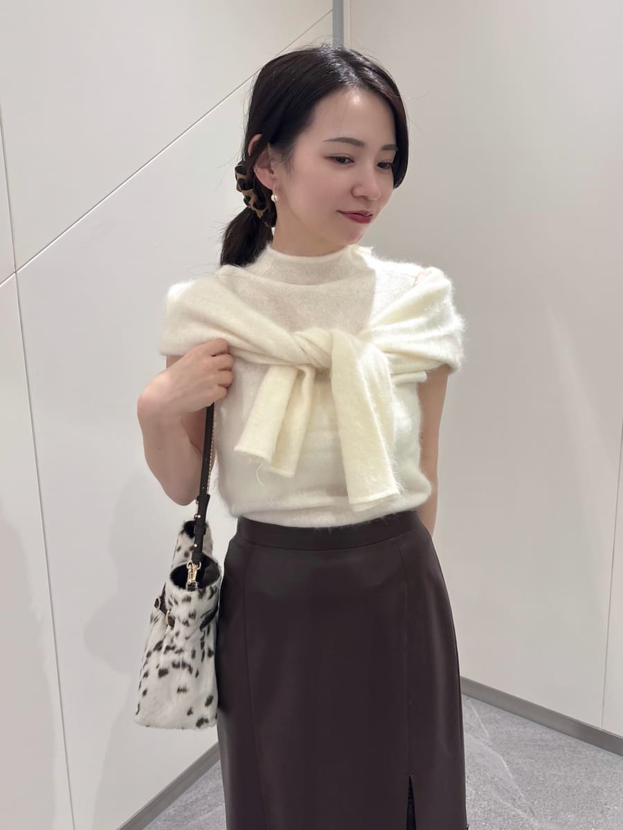 ブラウン系のスカート、ホワイト系のTシャツ/カットソー、ブラック系のブーツを着用したレディースの秋コーディネートの7枚目の写真