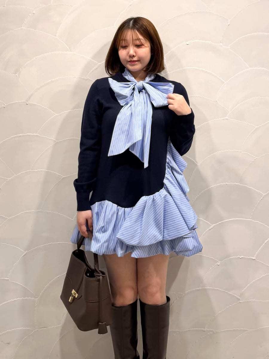 ブラウン系のハンドバッグ、ブルー系のワンピース、ブラウン系のブーツを着用したレディースの秋コーディネートの4枚目の写真