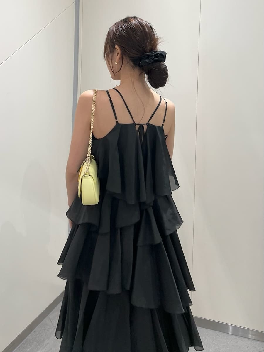 イエロー系のショルダーバッグ、イエロー系のカーディガン/ボレロ、ブラック系のドレスを着用したレディースの夏コーディネートの9枚目の写真