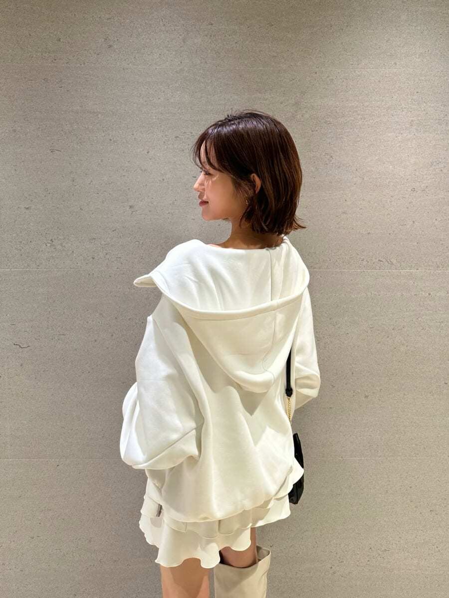 ホワイト系のパーカー、ホワイト系のブーツ、ブラック系のショルダーバッグを着用したレディースの冬コーディネートの7枚目の写真