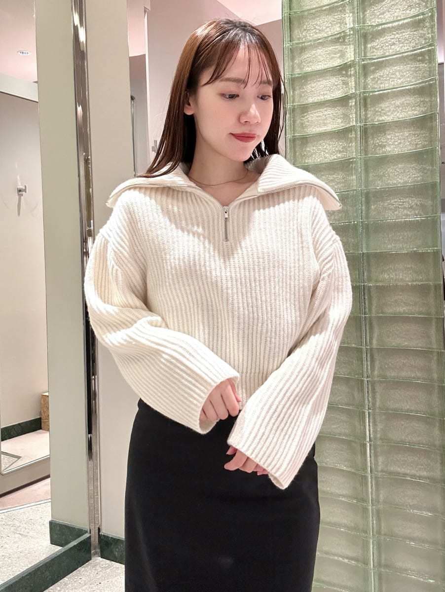 ホワイト系のニット/セーター、ブラック系のスカート、ホワイト系のハンドバッグを着用したレディースの秋コーディネートの2枚目の写真