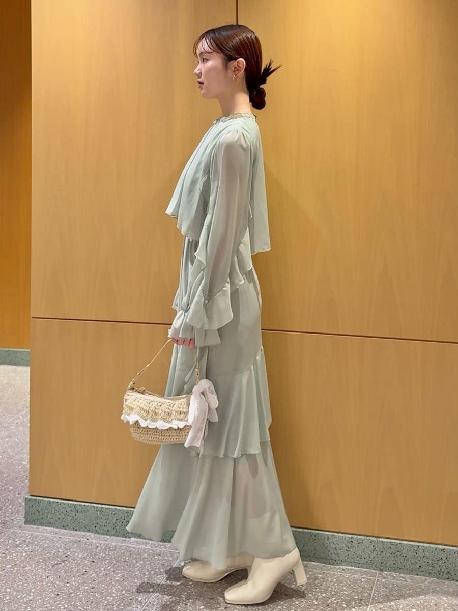 グリーン系のワンピース、ホワイト系のカーディガン/ボレロを着用したレディースの冬コーディネートの5枚目の写真