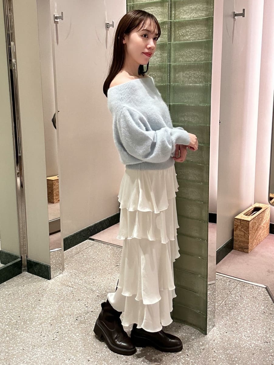 ブルー系のニット/セーター、ホワイト系のスカートを着用したレディースの秋コーディネートの4枚目の写真
