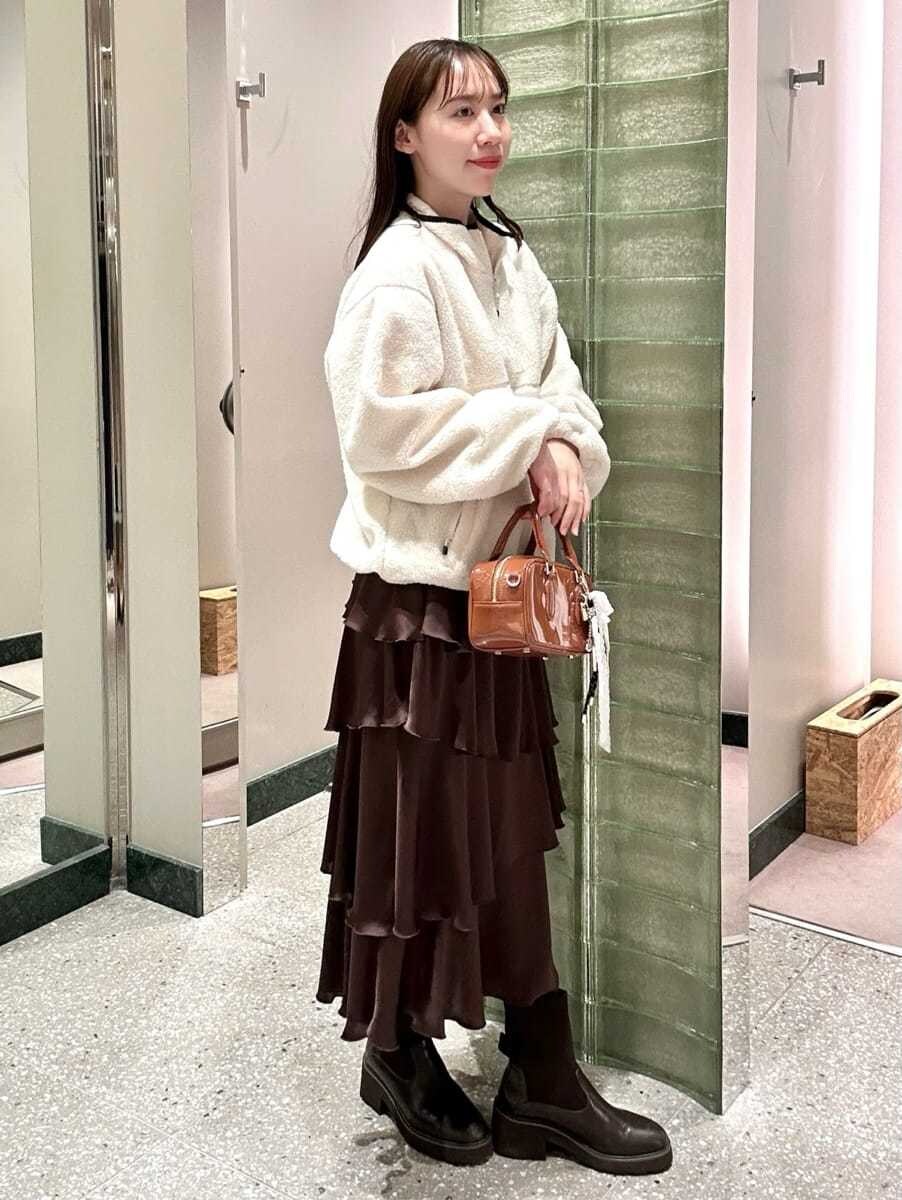 ホワイト系のTシャツ/カットソー、ブラウン系のスカート、イエロー系のボストンバッグを着用したレディースの秋コーディネートの4枚目の写真