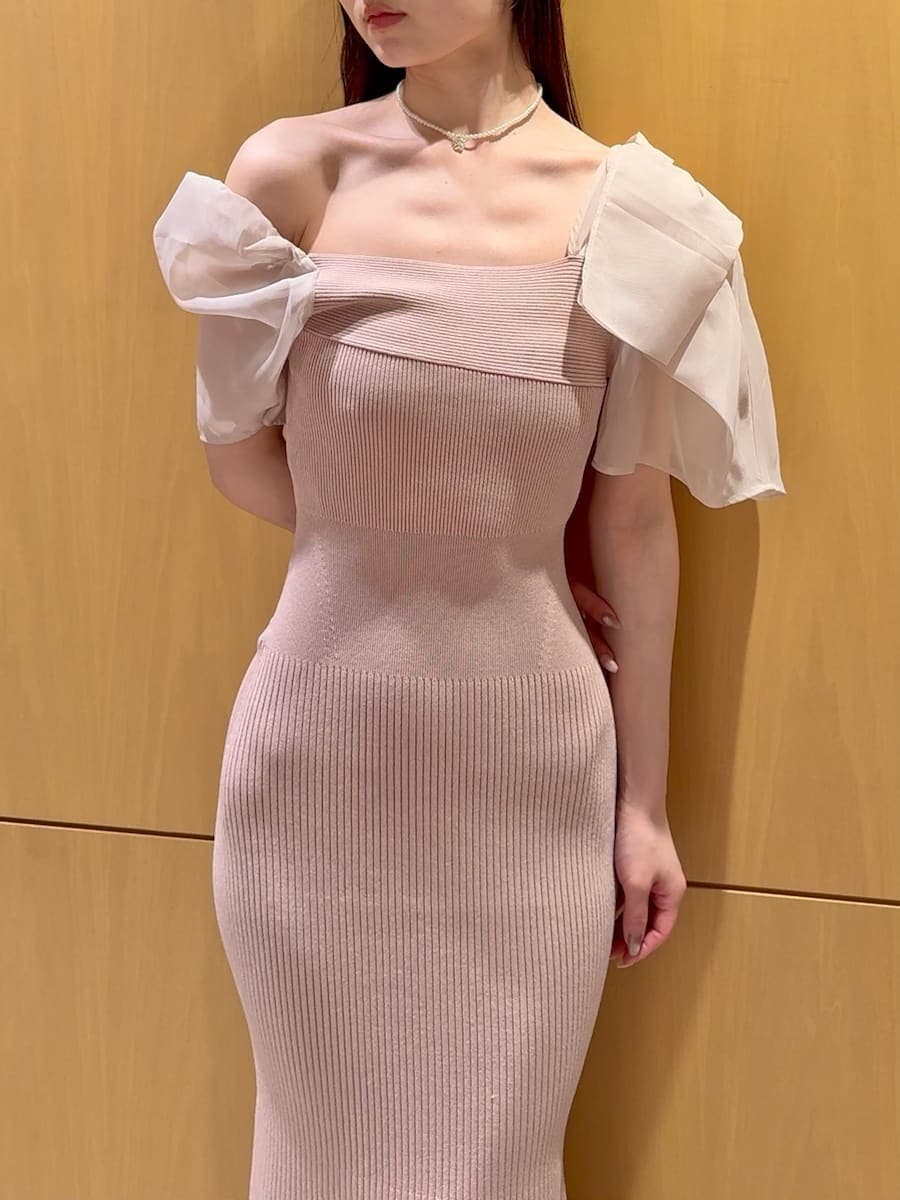 ピンク系のワンピース、ベージュ系のハンドバッグ、ホワイト系のネックレスを着用したレディースの春コーディネートの4枚目の写真