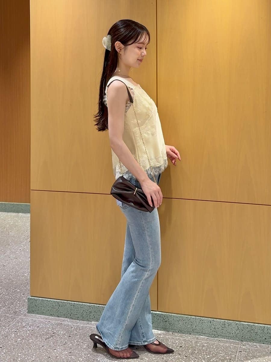 ブルー系のデニムパンツ、イエロー系のキャミソール、その他のイヤリングを着用したレディースの夏コーディネートの2枚目の写真