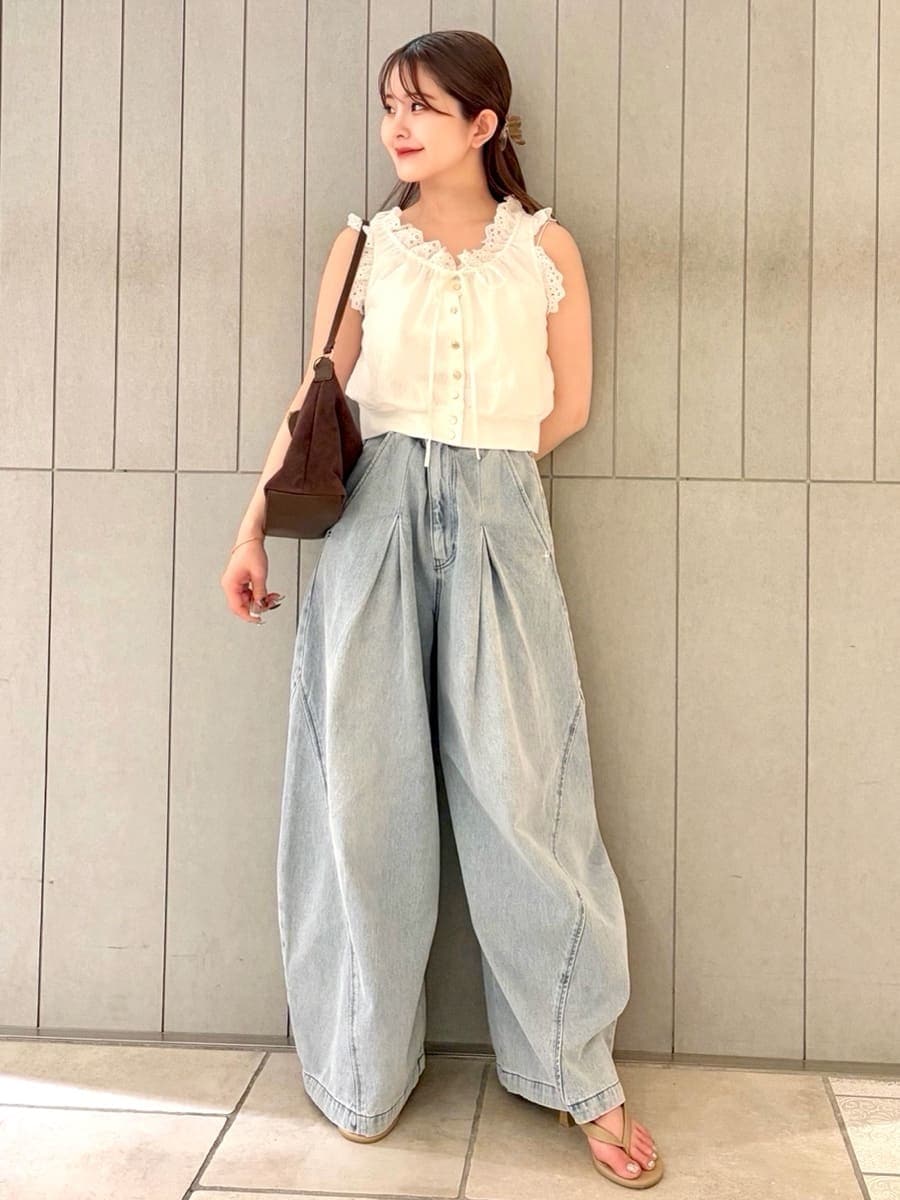 ブルー系のデニムパンツ、ホワイト系のシャツ/ブラウス、ブラウン系のショルダーバッグを着用したレディースの夏コーディネートの3枚目の写真