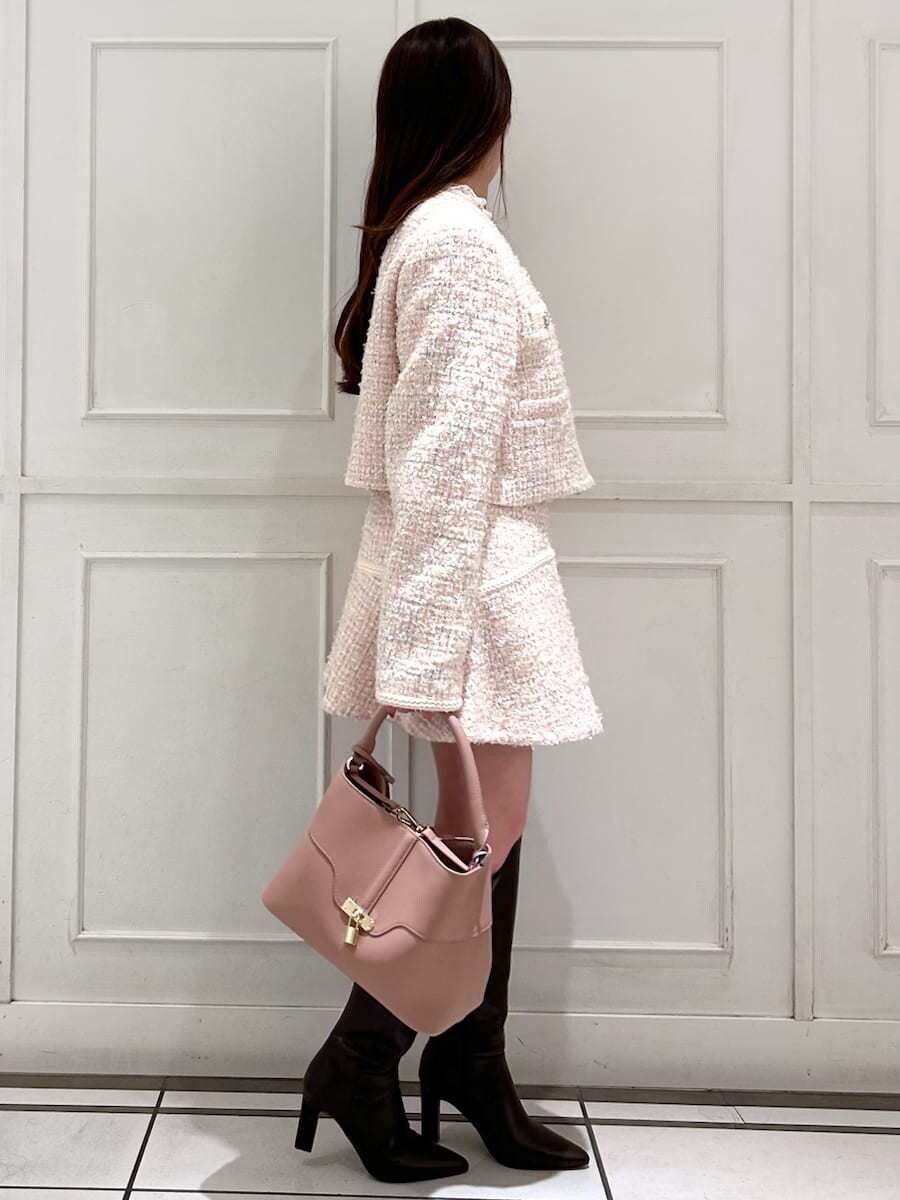 ピンク系のショルダーバッグ、ブラウン系のブーツ、その他のノーカラージャケットを着用したレディースの冬コーディネートの2枚目の写真