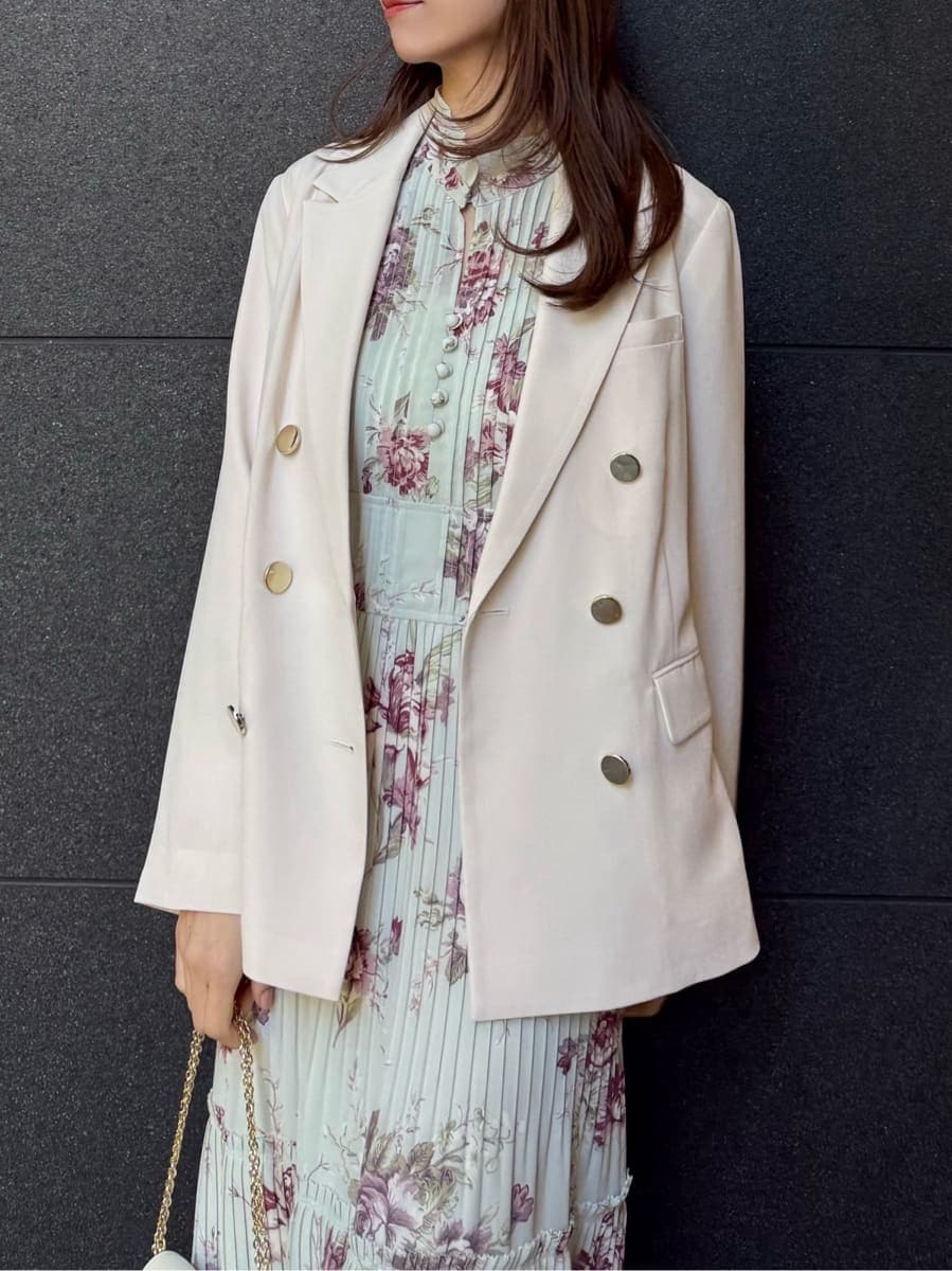 グリーン系のワンピース、ホワイト系のショルダーバッグ、ゴールド系のイヤリングを着用したレディースの春コーディネートの3枚目の写真