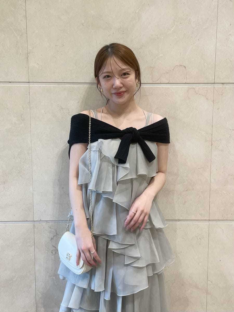 ブラック系のサンダル、ホワイト系のショルダーバッグ、グリーン系のドレスを着用したレディースの夏コーディネートの2枚目の写真