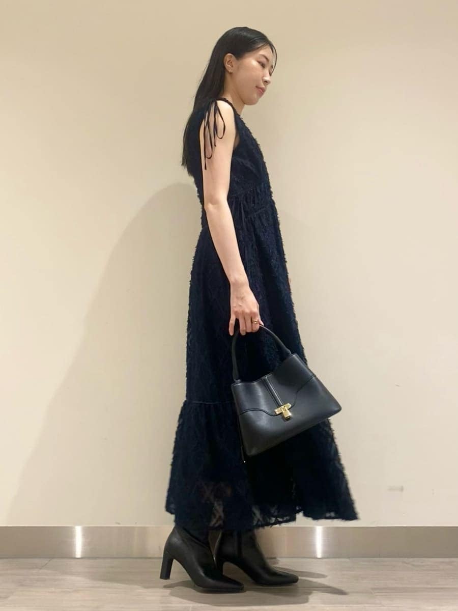 ブルー系のワンピース、ブラック系のブーツ、ブラック系のショルダーバッグを着用したレディースの秋コーディネートの2枚目の写真