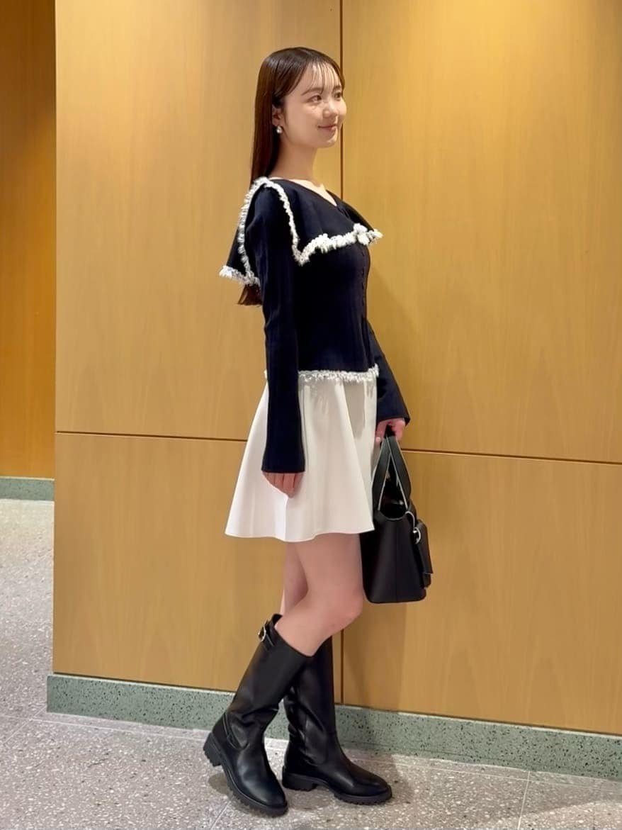 ブルー系のニット/セーター、ホワイト系のその他パンツ、ブラック系のハンドバッグを着用したレディースの冬コーディネートの3枚目の写真