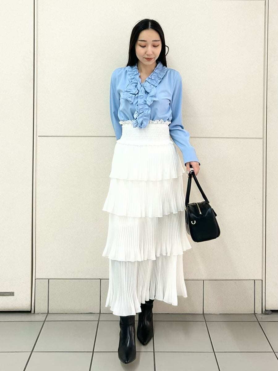 ブラック系のブーツ、ブルー系のシャツ/ブラウス、ホワイト系のスカートを着用したレディースの冬コーディネートの2枚目の写真