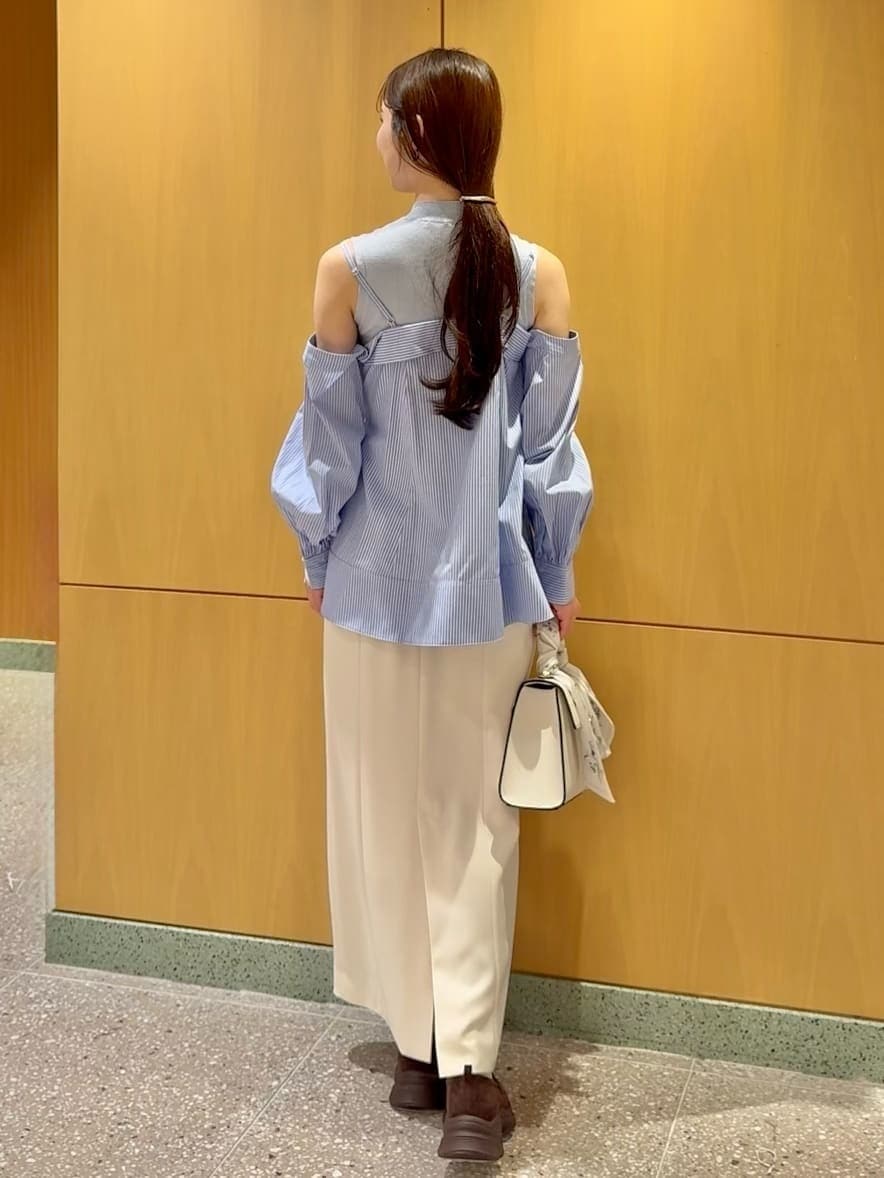 ホワイト系のスカート、ブルー系のニット/セーター、ベージュ系のハンドバッグを着用したレディースの冬コーディネートの3枚目の写真