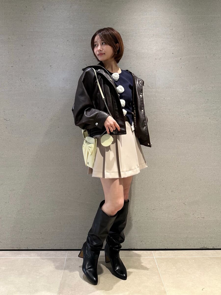ブラック系のブーツ、ブラウン系のブルゾン、ベージュ系のスカートを着用したレディースの冬コーディネートの2枚目の写真