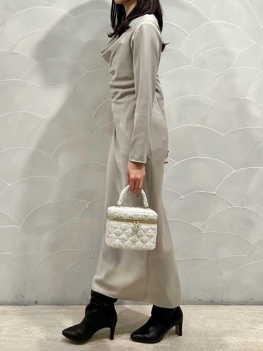 グリーン系のワンピース、ホワイト系のハンドバッグを着用したレディースの冬コーディネートの4枚目の写真