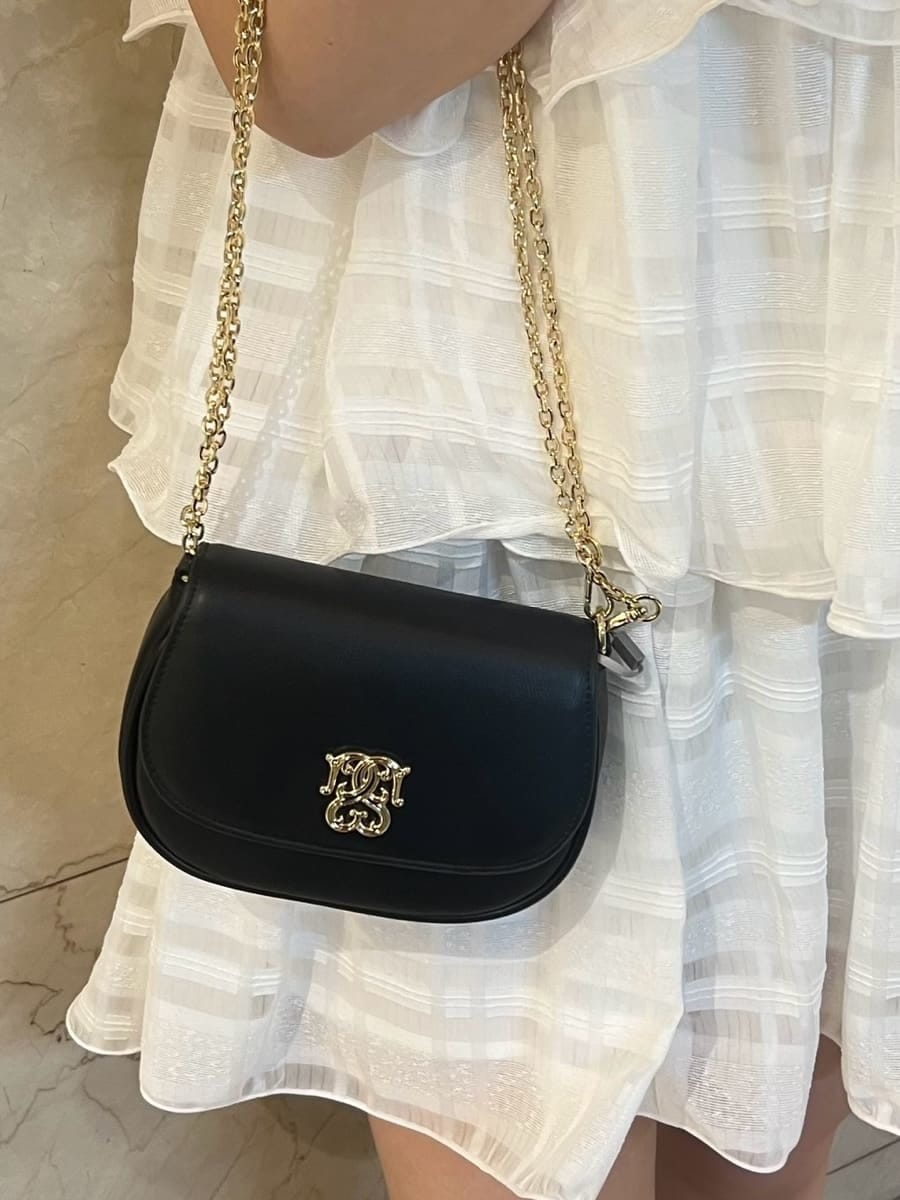 ホワイト系のワンピース、ブルー系のカーディガン/ボレロ、ブラック系のショルダーバッグを着用したレディースの春コーディネートの5枚目の写真