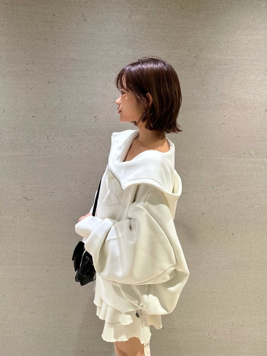 ホワイト系のパーカー、ホワイト系のブーツ、ブラック系のショルダーバッグを着用したレディースの冬コーディネートの6枚目の写真