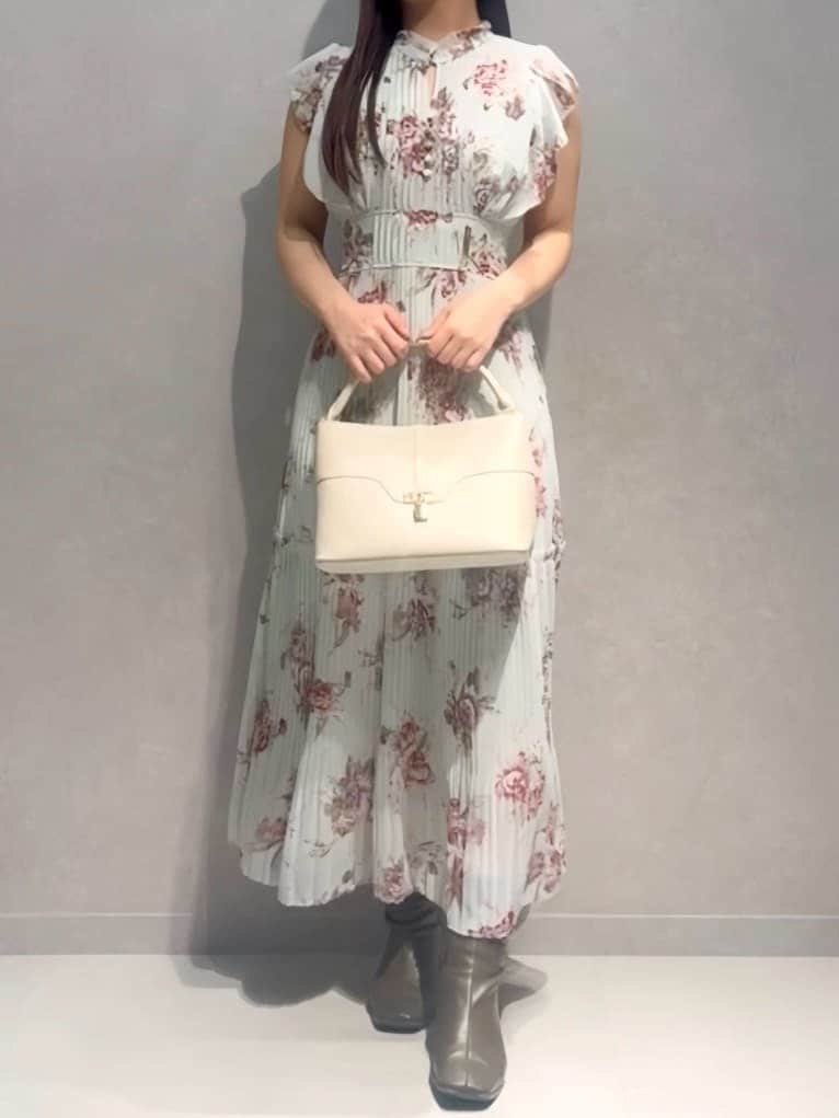 グリーン系のワンピース、ホワイト系のハンドバッグを着用したレディースの春コーディネートの2枚目の写真