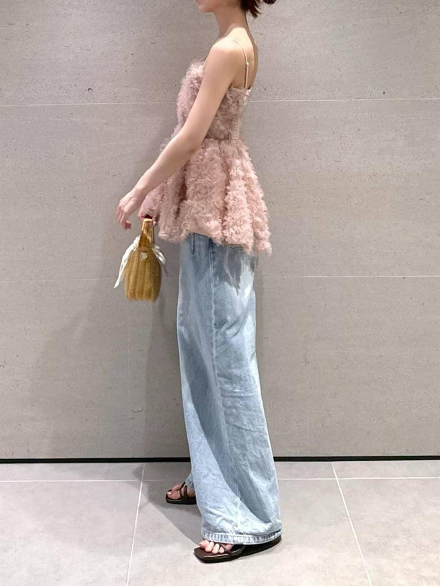 ホワイト系のかごバッグ、ブルー系のデニムパンツ、ブラウン系のサンダルを着用したレディースの夏コーディネートの2枚目の写真
