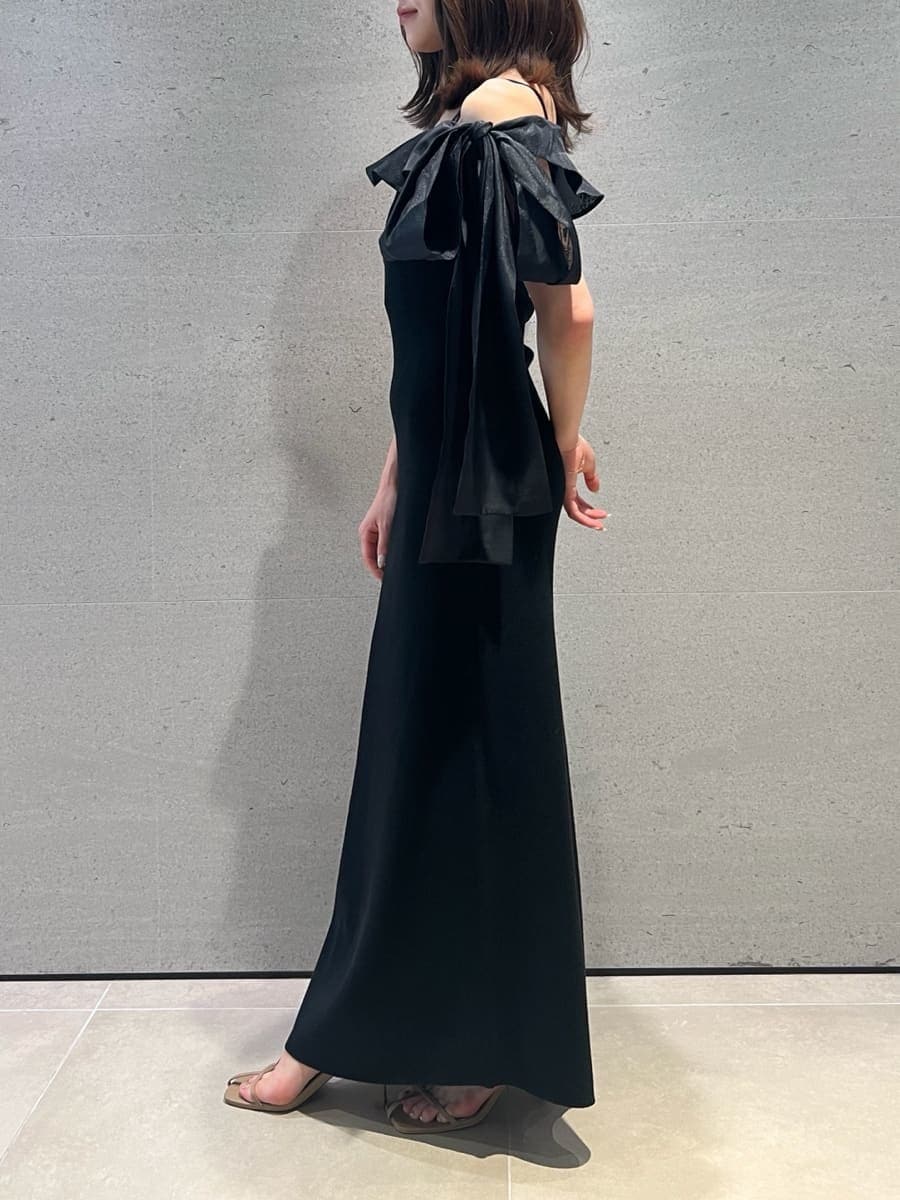 ブラック系のワンピース、イエロー系のボストンバッグ、ベージュ系のサンダルを着用したレディースの夏コーディネートの6枚目の写真