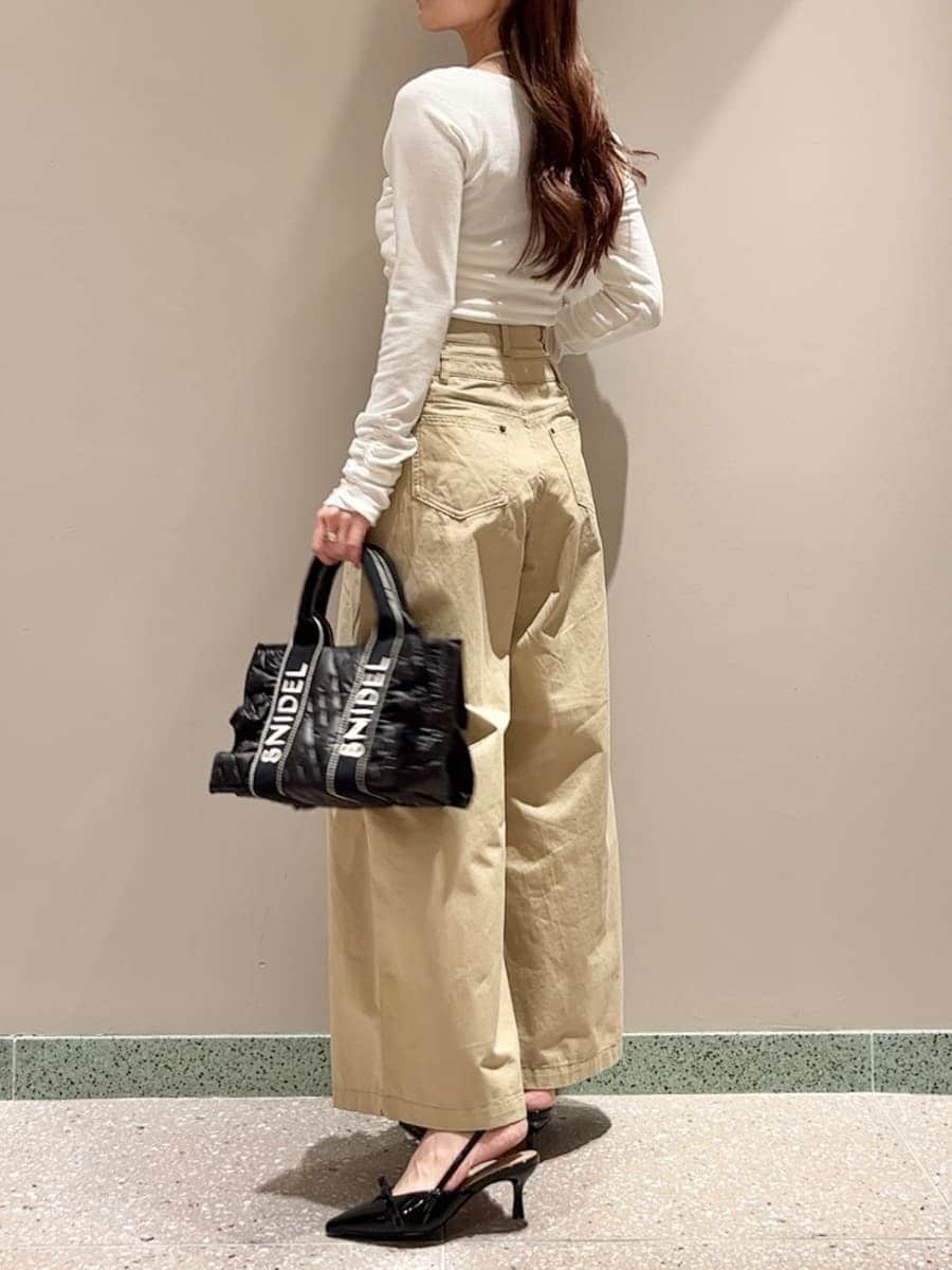 ホワイト系のTシャツ/カットソー、ベージュ系のデニムパンツ、ブラック系のハンドバッグを着用したレディースの秋コーディネートの3枚目の写真